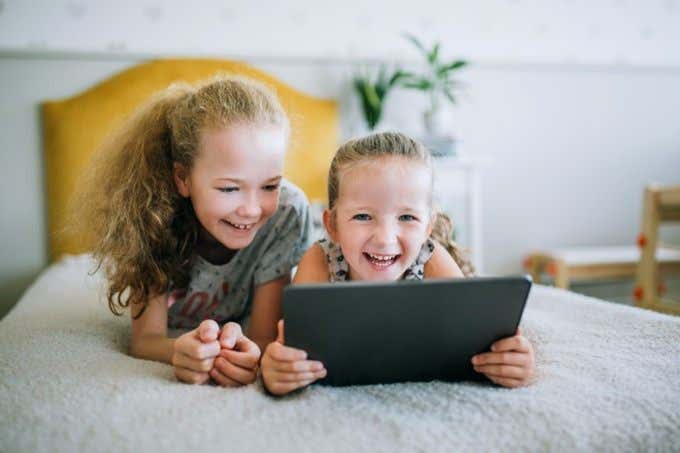 Children smiling and holding an iPad